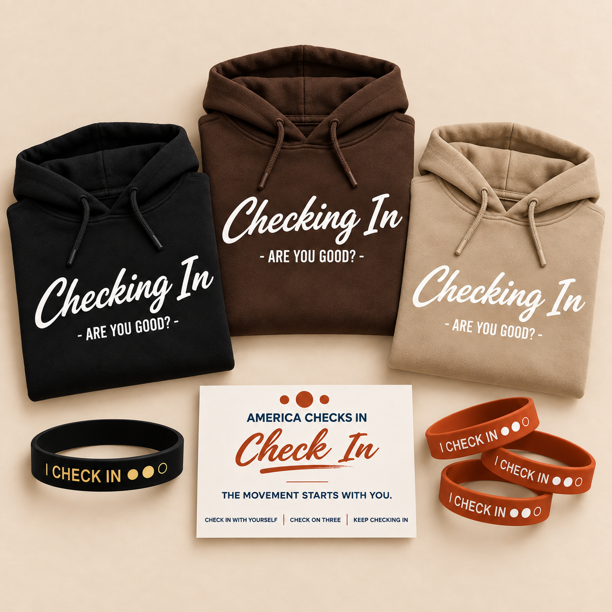 Black, brown and tan Checking In — Are You Good? hoodies with one Black + Gold I CHECK IN wristband, three Clay Rust I CHECK IN wristbands, the You Went First. Founding Check-In Leader card and the Original 100 #001 Founding Check-In Leader seal