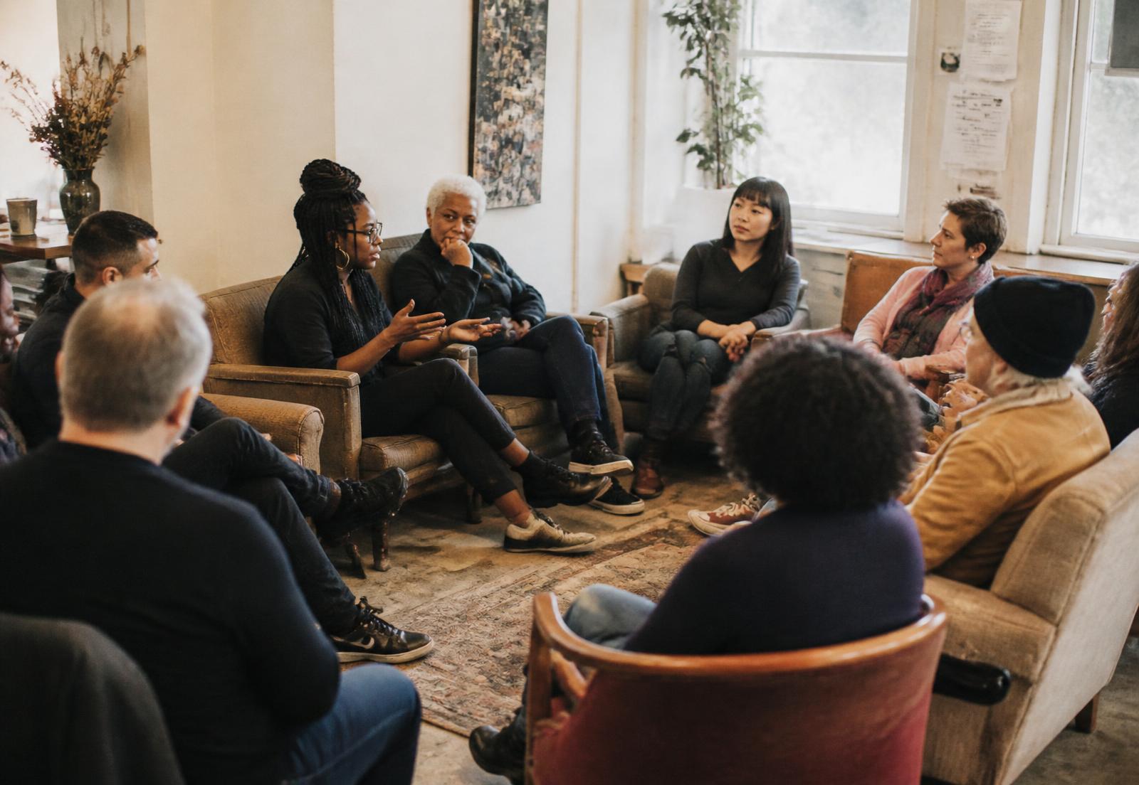 A diverse, multigenerational group listens to one another during a community check-in.